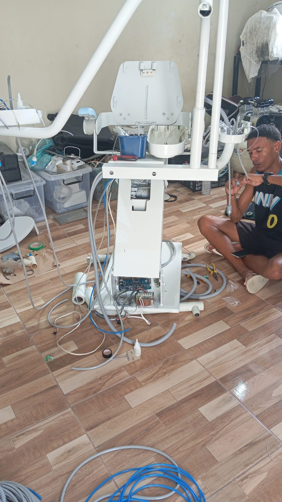 Técnico realizando reparo em equipamento odontológico